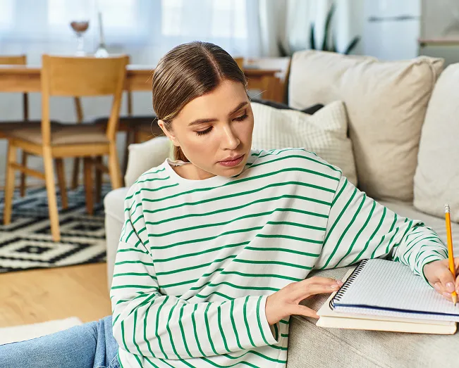 Young beautiful woman engaged creative writing cozy couch modern living room